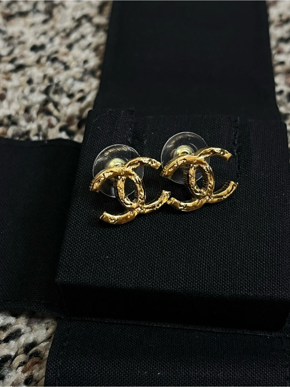 CHANEL Gold Interlocking CC Stud Earrings on Black